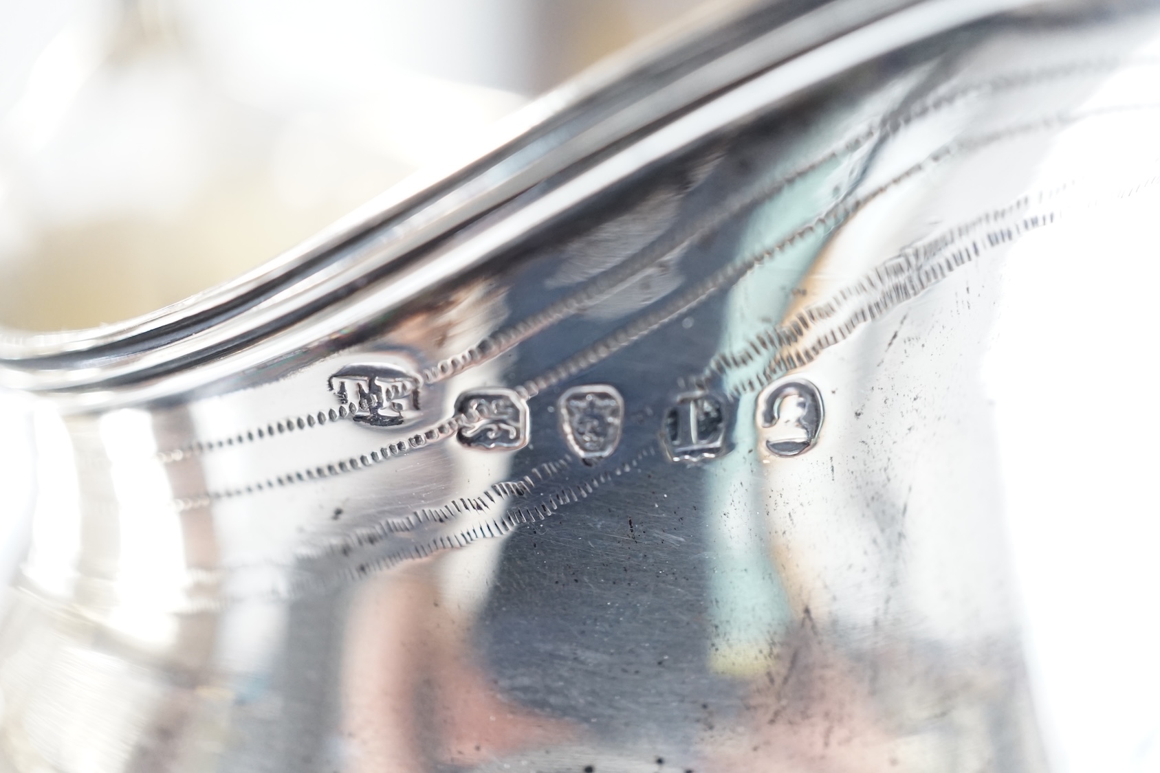 A George III silver helmet shaped cream jug, London, 1806, 10.2cm, together with another George III silver cream jug(repair). Condition - poor to fair